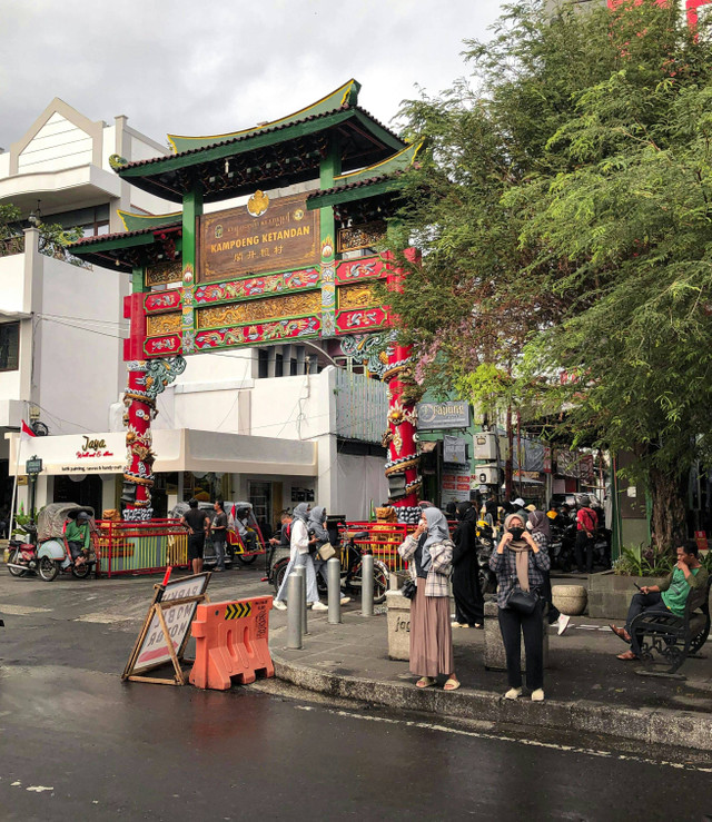 Sebuah pecinan di Yogyakarta. Tampak sekumpulan perempuan berhijab sedang berlalu lalang di depan gerbang pecinan. Hal tersebut menjadi potret toleransi dan kebersamaan antargolongan, dalam hal ini umat Islam dan masyarakat Tionghoa. Foto: Mardanafin.