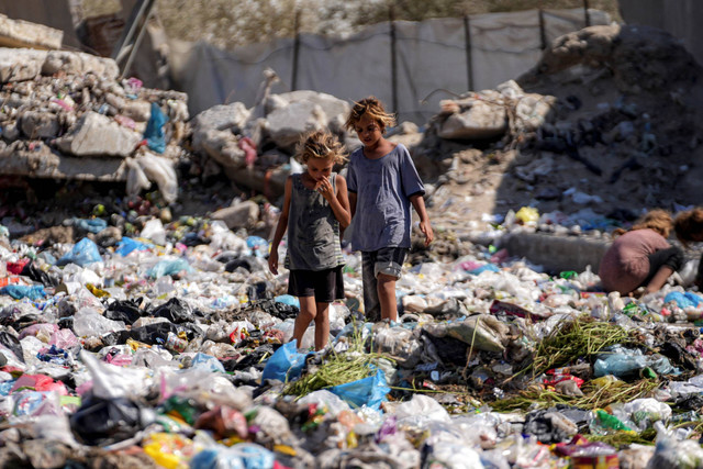 Anak-anak pengungsi Palestina memilah sampah di jalan di Deir al-Balah, bagian tengah Jalur Gaza, Kamis, 29 Agustus 2024. Foto: Abdel Kareem Hana / AP Photo