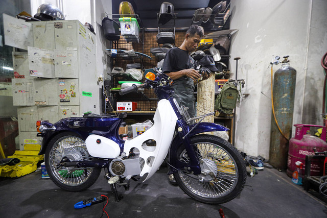 Teknisi mengkonversi sepeda motor berbahan bakar minyak menjadi sepeda motor listrik di Bengkel Elders Garage, Pancoran, Jakarta, Selasa (10/9/2024). Foto: Iqbal Firdaus/kumparan