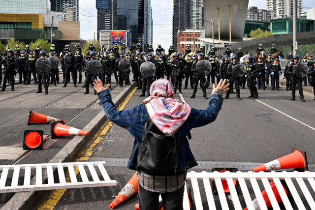 Polisi bentrok dengan pengunjuk rasa selama unjuk rasa menentang Pameran Pertahanan Darat Internasional Angkatan Darat di Pusat Konvensi dan Pameran Melbourne di Melbourne, Australia, Kamis (11/9/2024). Foto: Joel Carrett/AAP/via REUTERS