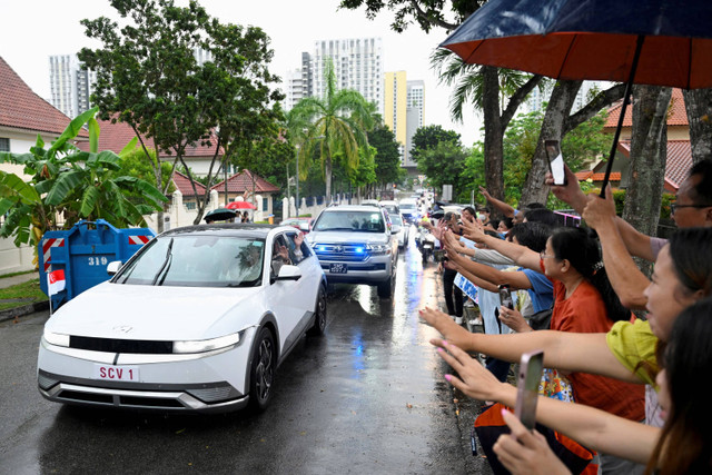 Paus Fransiskus menyapa warga saat tiba di Singapura, Rabu (11/9/2024). Foto: Caroline Chia/REUTERS