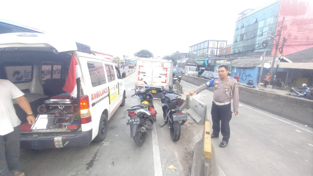 Petugas kepolisian melakukan penanganan kecelakaan mobil boks dan motor di Jalan Daan Mogot, Jakarta Barat, pada Kamis (12/9/2024). Foto: Dok. Istimewa