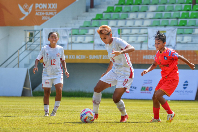 Pemain bola DKI Jakarta Carla Bio Pattinasarany menggiring bola melewati pemain bola Bangka Belitung Asi Tiayani pada pertandingan semifinal sepak bola putri PON XXI Aceh-Sumut di Stadion Mini Pancing, Deli Serdang Sumatera Utara, Kamis (12/9/2024). Foto: Fransisco Carolio/ANTARA FOTO