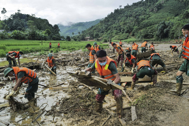 Petugas penyelamat menyaring puing-puing di lokasi tanah longsor usai dilanda Topan Yagi di desa pegunungan terpencil Lang Nu, di provinsi Lao Cai, Vietnam, Kamis (12/9/2024). Foto: AFP