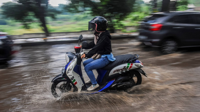 Pengendara roda dua menerobos genangan air akibat hujan lebat di Rangkasbitung, Lebak, Banten, Jumat (13/9/2024). Foto: Muhammad Bagus Khoirunas/ANTARA FOTO