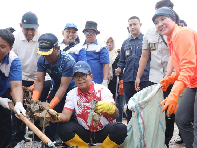 Pj Gubernur Lampung, Samsudin bersama Kepala Dinas Lingkungan Hidup Provinsi Lampung, Emilia Kusumawati dan warga sekitar dalam kegiatan Coastal Clean Up di pantai sukaraja | Foto : Eka Febriani / Lampung Geh