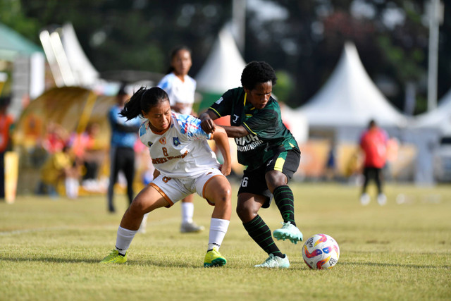 Pemain bola putri Bangka Belitung Firanda menggiring bola dihadang pemain bola putri Papua Pegunungan saat perebutan juara ketiga sepak bola putri PON XXI Aceh-Sumut di Stadion Mini Pancing, Deli Serdang, Sumatera Utara, Sabtu (14/9/2024). Foto: Iggoy el Fitra/Antara Foto