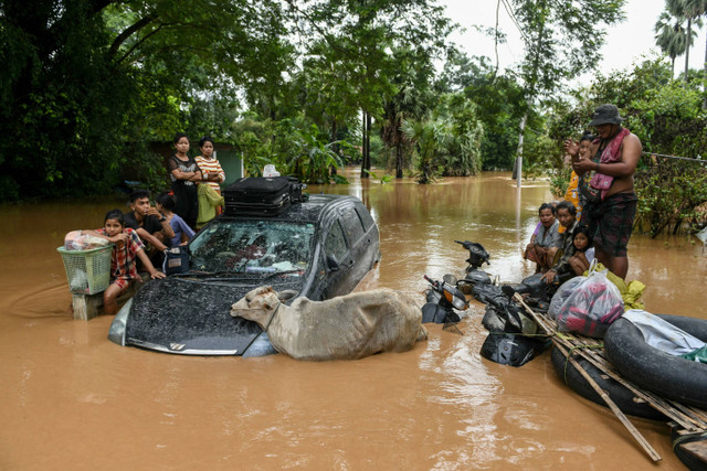 Sejumlah warga berkumpul di tempat yang lebih tinggi akibat banjir terjadi di Taungoo, Bago, Myanmar, Sabtu (14/9/2024). Foto: Sai Aung Main/AFP