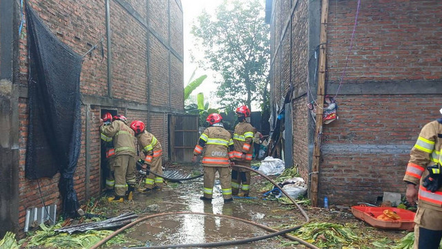 Petugas saat lakukan pemadaman kebakaran gudang pengeringan tembakau (oven) di Dusun Jatimalang, Desa Klepek, Kecamatan Sukosewu, Kabupaten Bojonegoro, Jawa Timur. Sabtu (14/09/2024). (Aset: Istimewa)