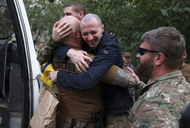 Prajurit Ukraina berpelukan dengan sesama prajurit setelah dibebaskan dari penawanan Rusia di lokasi yang dirahasiakan dekat perbatasan Ukraina-Belarusia, pada 13 September 2024. Foto: Anatolii STEPANOV / AFP