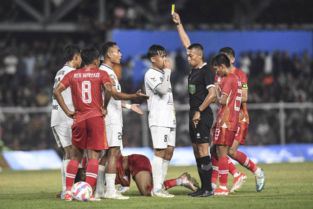 Wasit Eko Agus Sugiharto (kedua kanan) memberikan kartu kuning kepada pemain Sulawesi Tengah Ichansyah (ketiga kiri) saat melawan tim Aceh pada babak 8 besar PON XXI Aceh-Sumut 2024 di Stadion H Dimurthala, Banda Aceh, Aceh, Sabtu (14/9/2024). Foto: Adeng Bustomi/ANTARA FOTO 