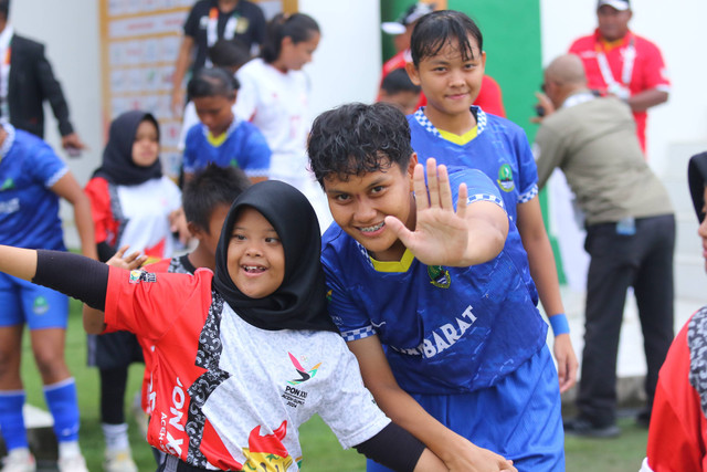 Pemain Jawa Barat, Agnes Hutapea, sedang berfoto dengan pendamping di final sepak bola wanita PON 2024 melawan DKI Jakarta, Sabtu (14/9). Foto: Dok. Ahmad Maherdika/@fotobolakita