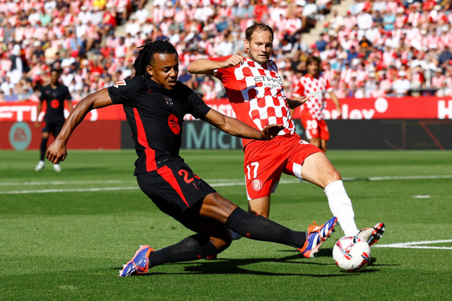 Pemain Girona Daley Blind berebut bola dengan pemain FC Barcelona Jules Kounde pada pertandingan Liga Spanyol di Estadi Montilivi, Girona, Spanyol, Minggu (15/9/2024). Foto: Albert Gea/REUTERS 