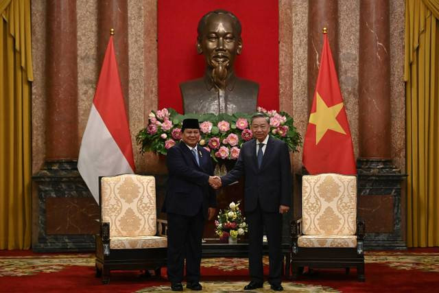 Menteri Pertahanan sekaligus Presiden terpilih Republik Indonesia Prabowo Subianto (kiri) berjabat tangan dengan Presiden Vietnam To Lam saat pertemuan di Hanoi, Vietnam, Jumat (13/9/2024). Foto: Nhac NGUYEN/AFP