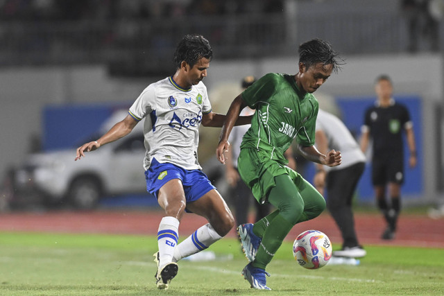 Pemain Aceh Muhammad Mufaddhal (kiri) berebut bola dengan pemain Jawa Timur Mochamad Rangga Saputra (kanan) pada pertandingan semifinal PON XXI Aceh-Sumut 2024 di Stadion Harapan Bangsa, Banda Aceh, Aceh, Senin (16/9/2024). Foto: Andreas Fitri Atmoko/ANTARA FOTO 