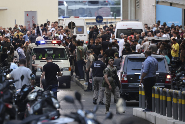 Ambulans dikerumuni orang-orang di pintu masuk American University of Beirut Medical Center ketika pager yang mereka gunakan untuk berkomunikasi meledak di seluruh Lebanon, menurut sumber keamanan, di Beirut, Lebanon, Selasa (17/9/2024). Foto: Anwar Amro/AFP