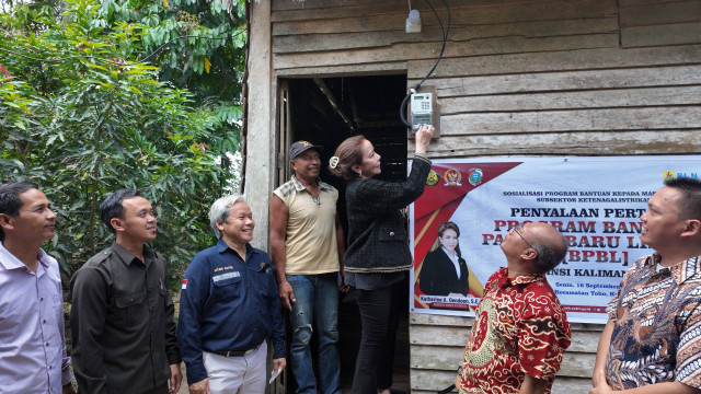 Penyalaan listrik secara simbolis Program Bantuan Pasang Baru Listrik (BPBL) di salah satu rumah warga penerima bantuan oleh Anggota Komisi VII DPR RI, Katherine A. Oendoen. Foto: Dok. PLN Kalbar