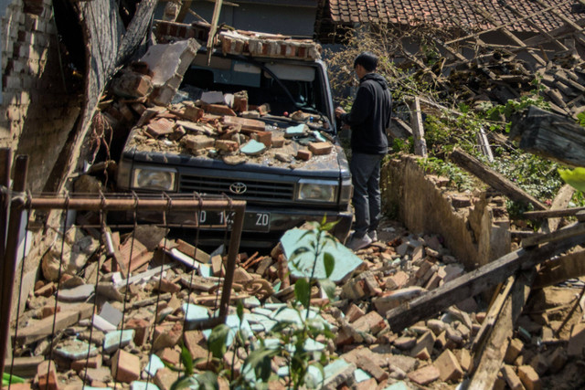 Warga membersihkan puing rumah yang runtuh pascagempa bumi di Desa Cibeureum, Kertasari, Kabupaten Bandung, Jawa Barat, Rabu (18/9/2024). Foto: Novrian Arbi/ANTARA FOTO