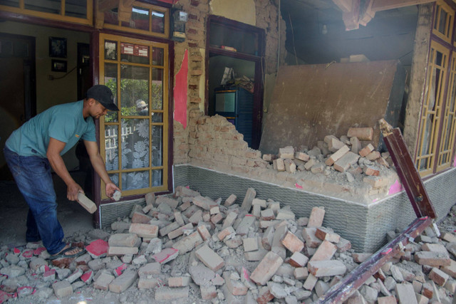 Warga membersihkan puing rumah yang runtuh pascagempa bumi di Desa Cibeureum, Kertasari, Kabupaten Bandung, Jawa Barat, Rabu (18/9/2024). Foto: Novrian Arbi/ANTARA FOTO