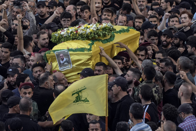 Para pelayat membawa peti mati Mohammed Mahdi, putra anggota parlemen Hizbullah Ali Ammar, yang tewas pada Selasa (17/9) setelah pager-nya meledak, di pinggiran selatan Beirut, Lebanon, Rabu (18/9/2024). Foto: Bilal Hussein/AP Photo