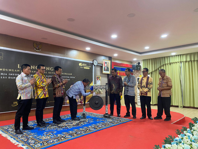 Bupati Sekadau Aron memukul gong saat meluncurkan program perlindungan sosial ketenagakerjaan. Foto: Dina Mariana/Hi!Pontianak