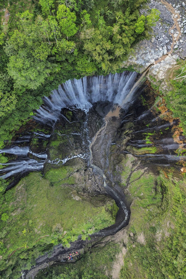 Wisatawan memperlihatkan aplikasi informasi wisata melalui ponsel miliknya saat mengunjungi wisata air terjun Tumpak Sewu di Ampelgading, Malang, Jawa Timur, Minggu (22/9/2024). Foto: Irfan Sumanjaya/ANTARA FOTO