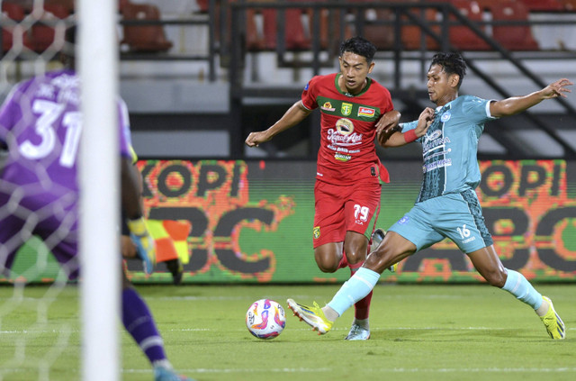 Pesepak bola PSBS Biak Muhammad Salman Alfarid (kanan) berusaha menghadang pesepak bola Persebaya Surabaya Malik Risaldi (tengah) saat pertandingan Liga 1 2024/2025 di Stadion Kapten I Wayan Dipta, Gianyar, Bali, Minggu (22/9/2024). Foto: Fikri Yusuf/ANTARA FOTO