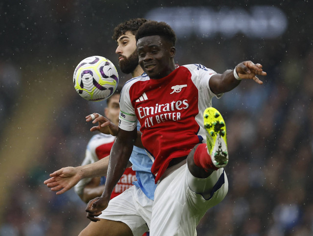 Pemain Man City, Josko Gvardiol, duel dengan pemain Arsenal, Bukayo Saka, dalam lanjutan Liga Inggris 2024/25 di Stadion Etihad, Manchester, Inggris, Minggu (22/9/2024). Foto: Jason Cairnduff/REUTERS