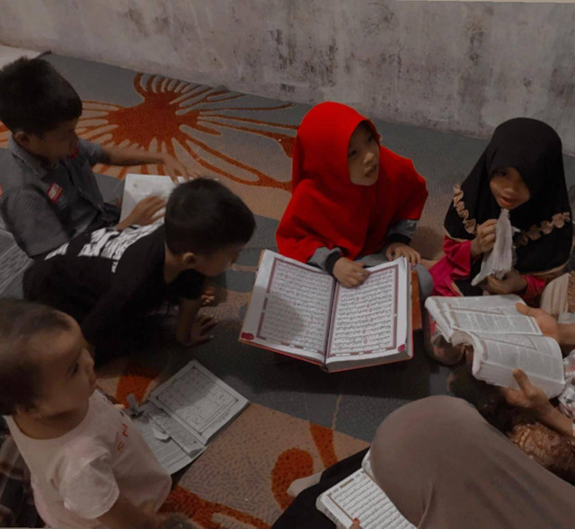 Anak-anak menggaji dengan penuh semanngat, terlihat pada malam dini hari disebuah tempat belajar Al-Qur'an.