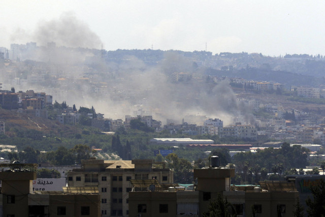 Asap mengepul dari lokasi serangan udara Israel di kota Ghaziyeh, Lebanon selatan, Senin (23/9/2024). Foto: Menahem Kahana/AFP