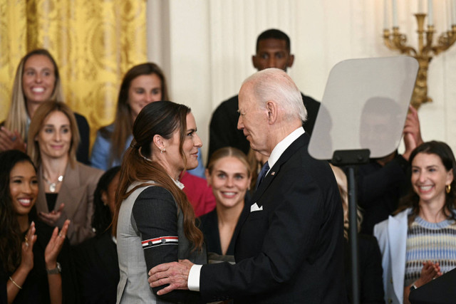 Presiden AS Joe Biden berbicara dengan Ali Krieger dalam sebuah acara untuk merayakan juara National Women's Soccer League (NWSL) Gotham FC 2023 di Ruang Timur Gedung Putih di Washington, DC, pada 23 September 2024. Foto: Brendan Smialowski/AFP