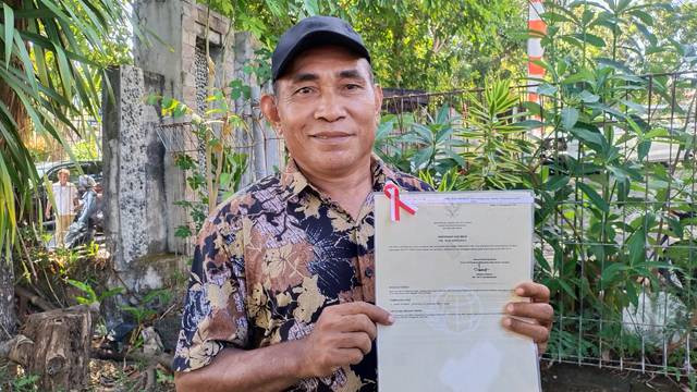 Andris Stirman, warga asal Kabupaten Sangihe menerima sertifikat tanah elektronik secara gratis dari Kanwil ATR/BPN Sulawesi Utara.