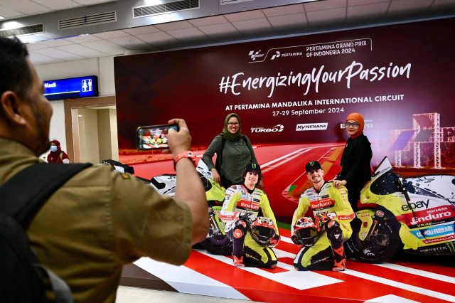 Antusias wisatawan saat berfoto di spot foto unik dengan papan menyerupai pembalap Tim VR46 MotoGP yang ada di Bandara Internasional Lombok. Selasa (24/9/2024). Foto: Dok. Pertamina