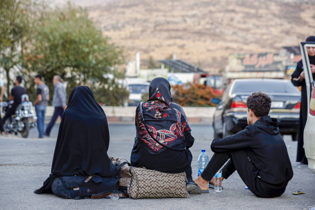 Warga Lebanon yang melarikan diri dari pemboman Israel, duduk di tanah setelah menyeberang ke Suriah di perbatasan Suriah-Lebanon di Jdaidet Yabous, Suriah, Selasa, 24 September 2024. Foto: AP Photo/Omar Sanadiki