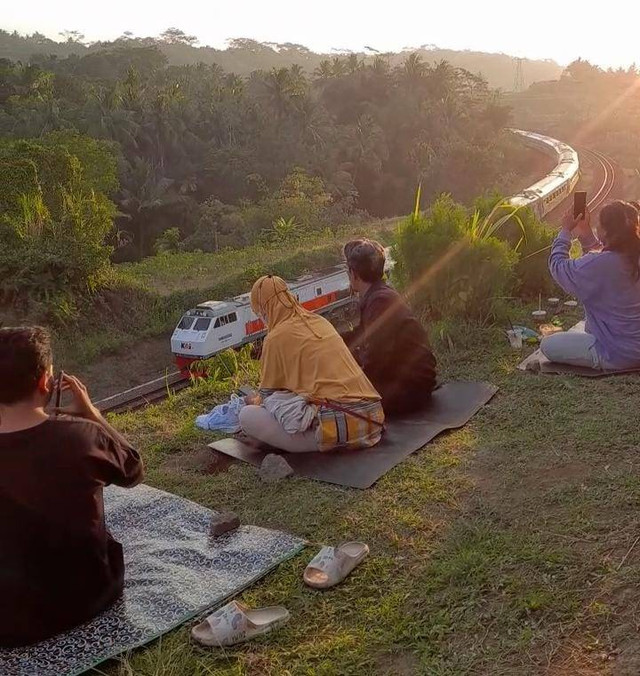 Pengunjung menanti senja dengan pemandangan kereta melintas di Serongan. (Dokumentasi pribadi penulis)