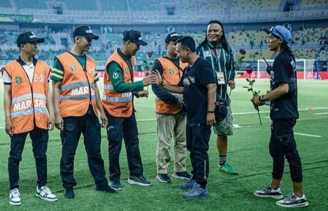 Pemberian bunga mawar kepada para steward yang bertugas saat laga Persebaya versus Dewa United, Jumat (27/9) malam. Foto: Official Persebaya