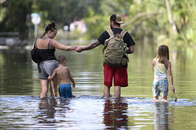 Warga melintasi banjir akibat Badai Helene, Jumat, 1 September. 27, 2024, di Crystal River, Florida Foto: AP Photo/Phelan M. Ebenhack