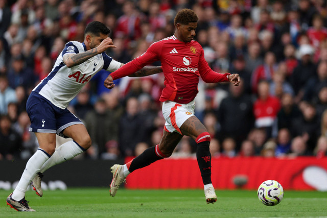 Pemain Manchester United Marcus Rashford berebut bola dengan pemain Tottenham Hotspur Cristian Romero pada pertandingan Liga Inggris di Old Trafford, Manchester, Inggris, Minggu (29/9/2024). Foto: Lee Smith/REUTERS 