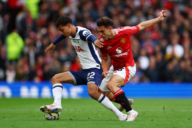 Pemain Manchester United Manuel Ugarte berebut bola dengan pemain Tottenham Hotspur Brennan Johnson pada pertandingan Liga Inggris di Old Trafford, Manchester, Inggris, Minggu (29/9/2024). Foto: Molly Darlington/REUTERS