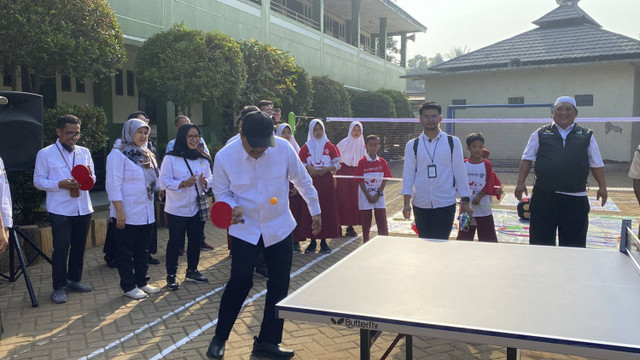 Momen Menteri Sosial, Saifullah Yusuf atau Gus Ipul bermain tenis meja sebelum memberi bantuan Asistensi Rehabilitasi Sosial (Atensi) pada pemulung dan bantuan alat pendidikan ke sekolah dasar di Bantar Gebang, Bekasi pada Senin (30/9/2024). Foto: Abid Raihan/kumparan