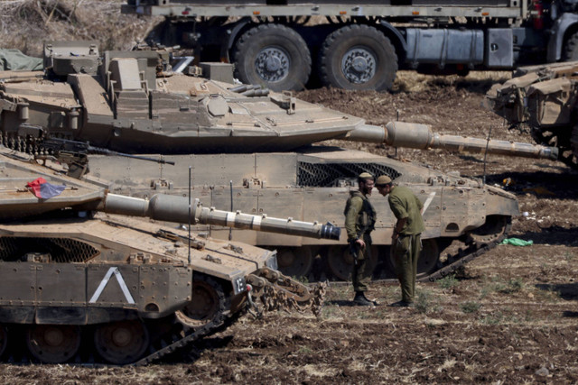 Anggota militer Israel berdiri di samping kendaraan lapis baja, di tengah permusuhan lintas batas antara Hizbullah dan Israel, di Israel utara, Senin (30/9/2024). Foto: Gil Eliyahu/REUTERS