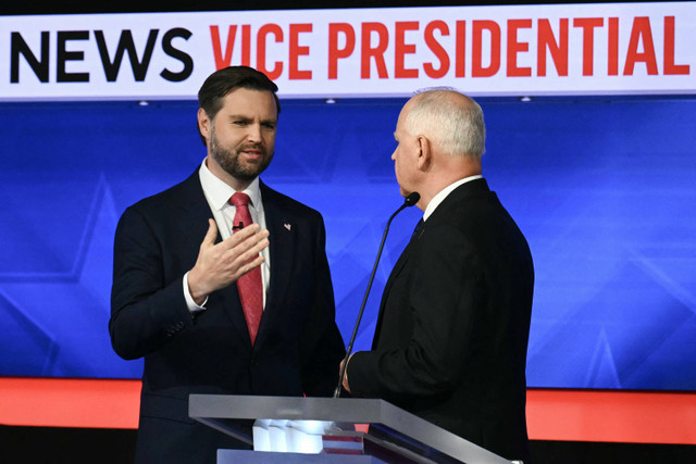 Senator AS dan calon wakil presiden dari Partai Republik J.D. Vance (kiri) dan Gubernur Minnesota dan calon wakil presiden dari Partai Demokrat Tim Walz berbicara satu sama lain di akhir debat Wakil Presiden yang diselenggarakan oleh CBS News di CBS. Foto: ANGELA WEISS / AFP