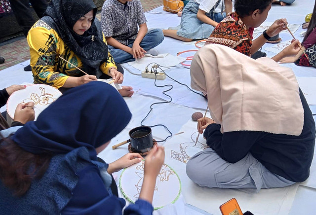 Anak-anak disabilitas tuli dan wicara asyik membatik di atas kain sprei bekas. Foto: Masruroh/Basra