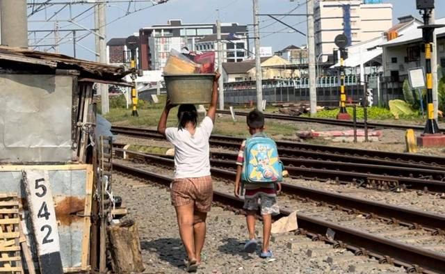 Seorang perempuan dan anaknya sedang mengangkut barang-barang di Bong Suwung Yogyakarta, Jumat (27/9). Foto: Widi RH Pradana/Pandangan Jogja