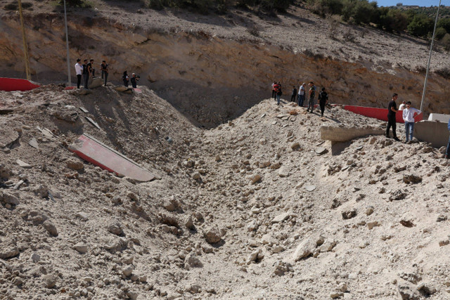 Warga berjalan melewati jalanan yang rusak imbas serangan Israel di perlintasan perbatasan Masnaa dengan Suriah, Lebanon, Jumat (4/10/2024). Foto: Mohamed Azakir/REUTERS 