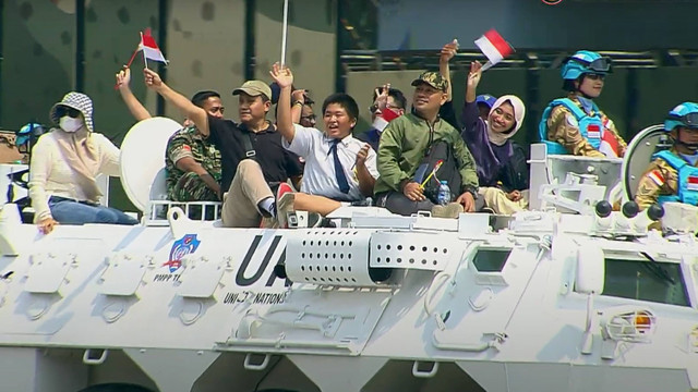 Sejumlah warga mengikuti defile kendaraan alutsista saat peringatan HUT ke-79 TNI di kawasan Monumen Nasional, Jakarta, Sabtu (5/10/2024). Foto: Youtube/Puspen TNI