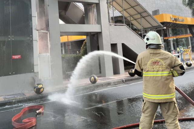 Petugas Damkar memadamkan api saat lift JPO Delta Plaza terbakar di Surabaya, Sabtu (5/10/2024). Foto:  Farusma Okta Verdian/kumparan