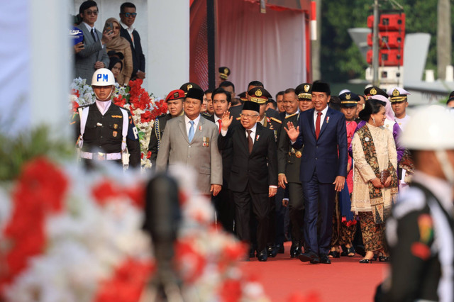 Presiden Jokowi (tengah) dan menteri Pertahanan sekaligus presiden terpilih 2024-2029 Prabowo Subianto menyapa para warga usai menghadiri upacara peringatan HUT ke-79 TNI di kawasan Monumen Nasional, Jakarta, Sabtu (5/10/2024). Foto: Dok. Istimewa