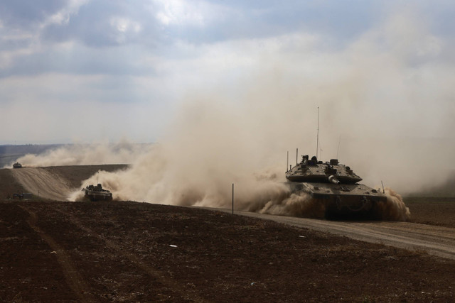 Tank-tank militer Israel melaju di sebuah area dekat perbatasan selatan Israel dengan Jalur Gaza, Minggu (6/10/2024). Foto: Menahem Kahana/AFP