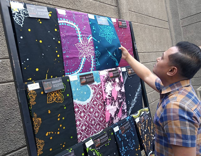 Seorang pengunjung sedang melihat batik ciprat dan cap  karya ODGJ Liponsos Keputih Surabaya. Foto: Masruroh/Basra